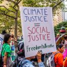 Protestor holds sign reading "climate justice is social justice"